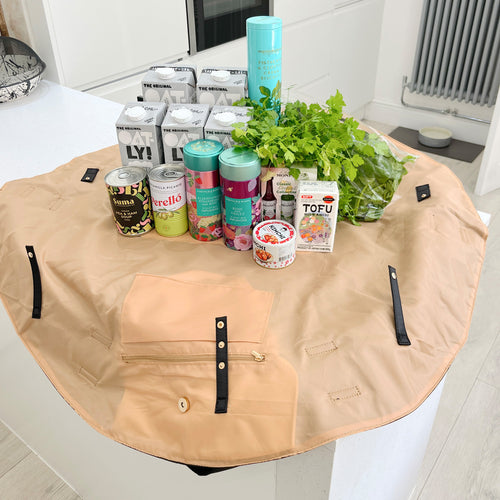 OYSTER lay-flat tote opened flat with food shopping inside, showing the spacious easy-to-pack design.