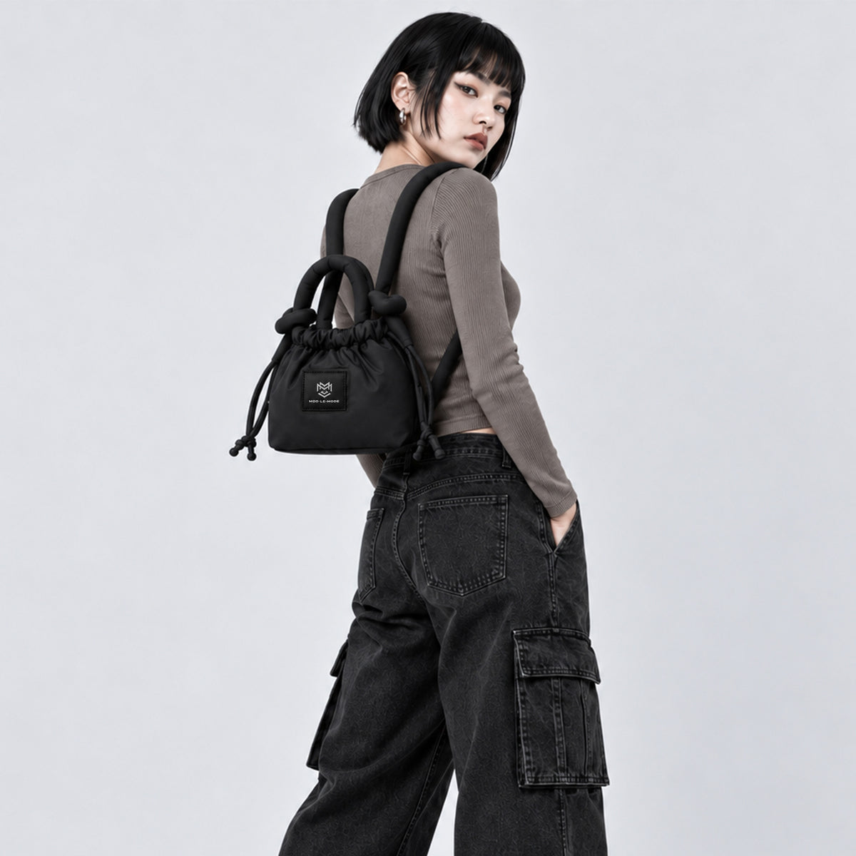 Black PUFFER Mini multiway tote bag worn as a backpack, showing its convertible design and padded straps for hands-free carrying.