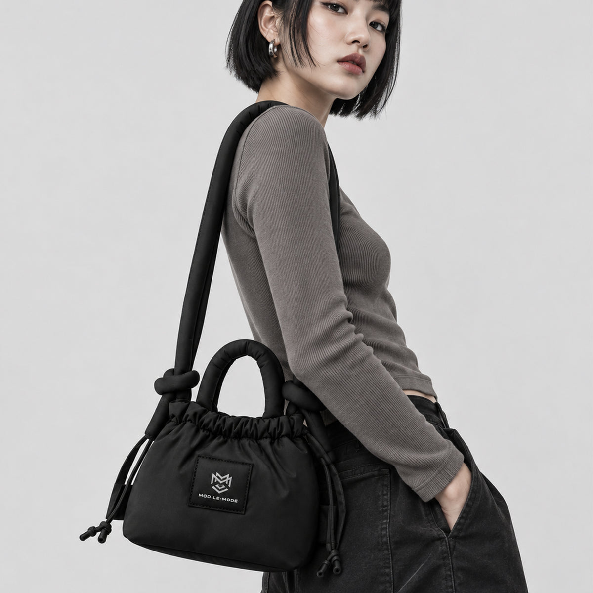 Black MOD-LE-MODE PUFFER Mini multiway tote bag worn as a shoulder bag, showing its lightweight padded design and soft shoulder strap.